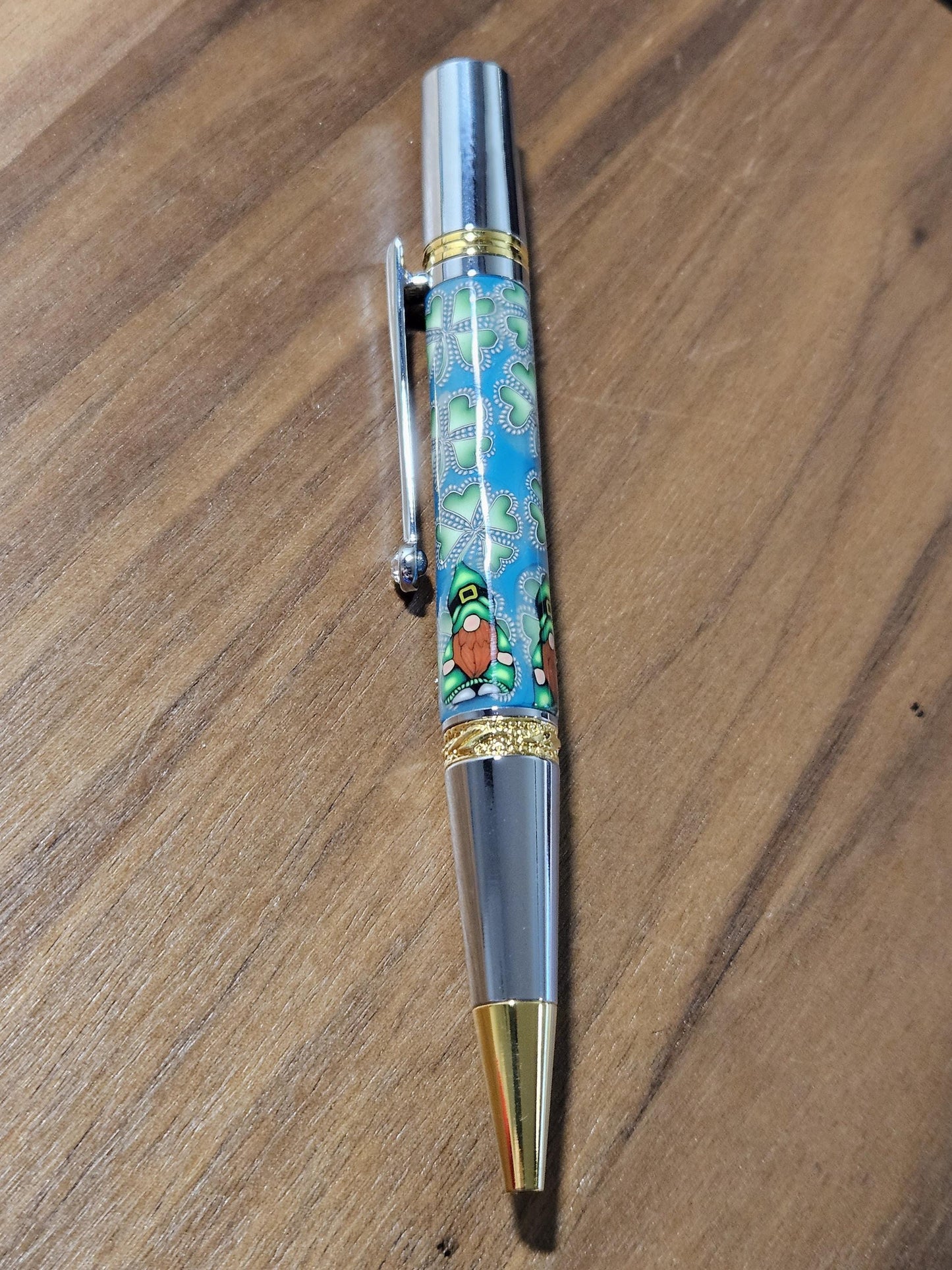 Polymer Clay Gnome Leprechaun Pen with Green Shamrocks, a Blue Background, Chrome and Gold Accents, and Featuring a Majestic Squire Pen Kit