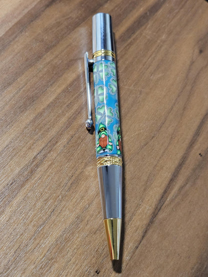 Polymer Clay Gnome Leprechaun Pen with Green Shamrocks, a Blue Background, Chrome and Gold Accents, and Featuring a Majestic Squire Pen Kit
