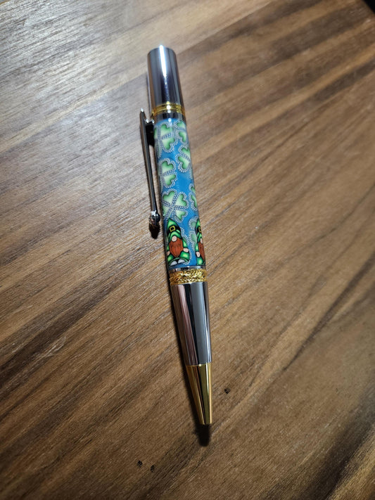 Polymer Clay Gnome Leprechaun Pen with Green Shamrocks, a Blue Background, Chrome and Gold Accents, and Featuring a Majestic Squire Pen Kit