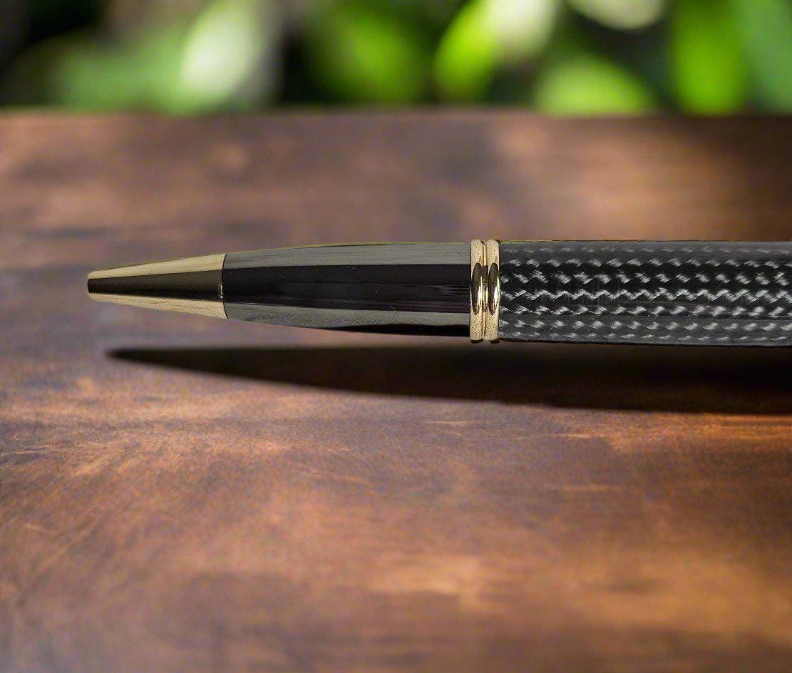 Round Top Black Carbon Fiber Sleeve Pen Cast in Resin with a Gold and Gunmetal Pen Kit